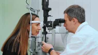 Göz doktorunda ya da göz doktorunda refraktometreyle ölçülen gözler. Klinikte klinikte genç bir kadının göz içi basıncını ölçen oftalmolog.