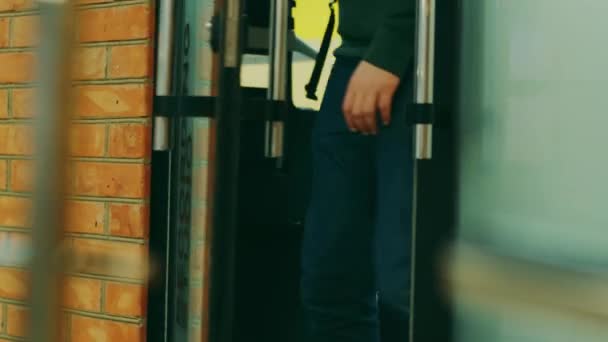 一个穿蓝色牛仔裤的男人从录音棚门口出来 — 图库视频影像