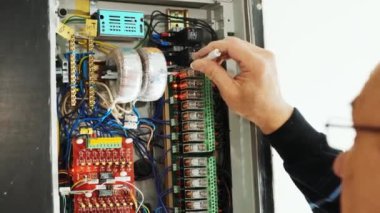 Elektrikçiler kontrol panelindeki elektrik akımını test ediyorlar. Elektrik mühendisi, kabine kontrolündeki voltaj ve elektrik hattının akımını ölçen bir testçi..