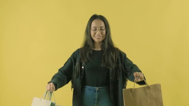 Menina Bonita Nova Com Sacos Compras Backgroun Amarelo — Vídeo de Stock