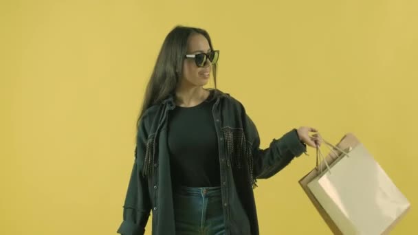 Gadis Cantik Muda Dengan Tas Belanja Pada Backgroun Kuning — Stok Video