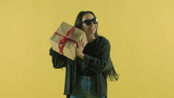 Щаслива Дівчина Подарунковою Коробкою Дивиться Камеру Жовтому Тлі — стокове відео