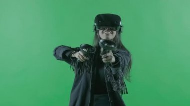 VR kulaklıkla oynayan genç bir kadın. Yeşil arka planda sanal gerçeklik kaskı. Krom Anahtar