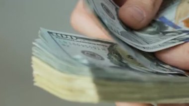 Erkeklerin elleri hızlıca banknotları sayar. İş adamı elinde dolarları sayar. USD