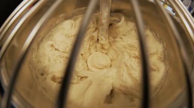 Close-up of dough mixing in a professional kneader machine in kitchen of bakery or at the manufacturing. Stock footage. Dough making process