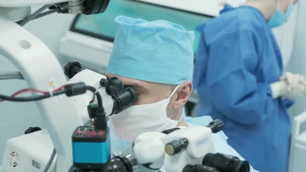 Chirurg Kijkt Naar Microscoop Het Oog Van Een Vrouwelijke Patiënt — Stockvideo