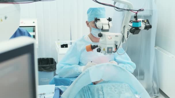 Chirurg Schaut Operationssaal Ins Mikroskop Auf Das Auge Einer Patientin — Stockvideo