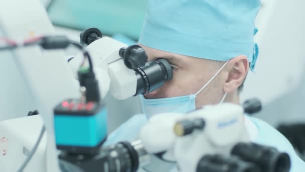 外科医生在手术室用显微镜观察女病人的眼睛 医生在眼科手术 白内障治疗及屈光矫正中使用显微镜 — 图库视频影像