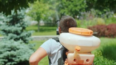 Ekolojik böcek ilacı sıkın. Çiftçi koruyucu maske, cam ağaçlar ve çalılarla dezenfekte ediyor. Zehirli böcek ilacı, böcek ilacı, böcek ilacı sıkan bir adam. Bahçıvanın bir bahçesi var.