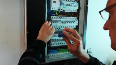 Elektrikçilerin elleri kontrol panelinde akım elektriği üzerinde çalışıyor. Elektrik mühendisi.