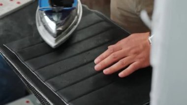 Adam ütü masasında ütüler mavi buharlı demirle