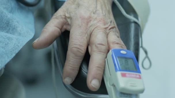 病院で手術中のモニタリングのために指にパルス酸素濃度計を持つ古い患者 — ストック動画