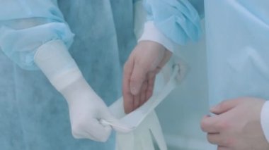 Hemşireye asistanlık ve hastanedeki ameliyathanede eldivenlere yardım.