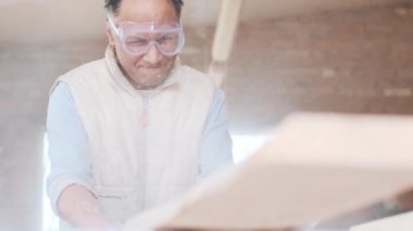 Marangoz atölyede ahşap ve dairesel testere ile çalışır.