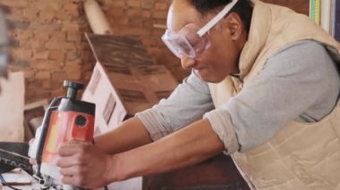 Atölyedeki bir işçinin elinde elektrikli değirmen makası. Bir işe başlamak. Zanaatkar