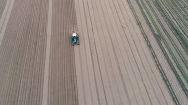 Sahaya sulama sistemi kuruluyor. Sahada çalışan traktörün hava görüntüleri. Havuç ekiyorum.