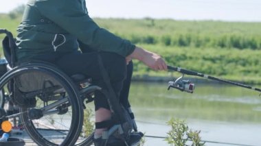 Gölde balık tutan engelli bir adam. Tekerlekli sandalye. Kamp yapmak. Yaz zamanı.