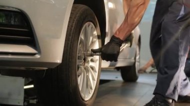 Garaj atölyesinde araba lastiği değiştiren tamirci. Ağır çekim. Otomatik servis