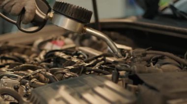 Otomobil tamircisi motor yağını otomobil istasyonundaki bir motora dönüştürüyor. Modern ekipmanlarla otomatik yağ değişimi