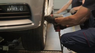 Garaj atölyesinde araba lastiği değiştiren tamirci. Ağır çekim. Otomatik servis