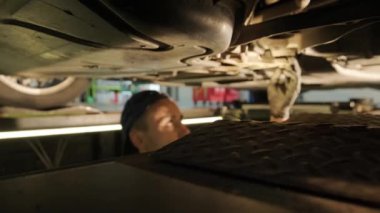 Otomobil servisinde araba süspansiyon testi. Otomobil servisindeki arabanın şasisi inceleniyor. Servis aracının onarımı ve bakımı.