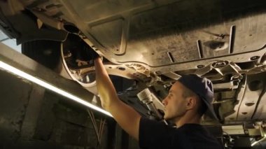 Otomobil servisinde araba süspansiyon testi. Otomobil servisindeki arabanın şasisi inceleniyor. Servis aracının onarımı ve bakımı.