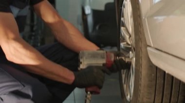 Garaj atölyesinde araba lastiği değiştiren tamirci. Ağır çekim. Otomatik servis