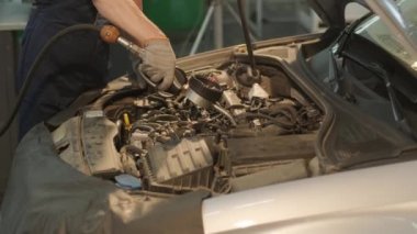 Otomobil tamircisi motor yağını otomobil istasyonundaki bir motora dönüştürüyor. Modern ekipmanlarla otomatik yağ değişimi