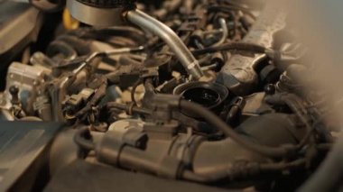 Otomobil tamircisi motor yağını otomobil istasyonundaki bir motora dönüştürüyor. Modern ekipmanlarla otomatik yağ değişimi