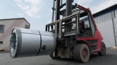 Forklift sürücüsü çelik levha yükler. Çelik kaplamalı sanayi deposu