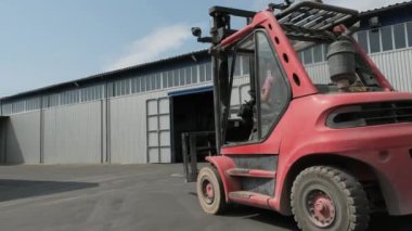 Forklift sürücüsü çelik levha yükler. Çelik kaplamalı sanayi deposu