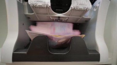 Kasiyer parayı sayıp kasaya koyuyor.