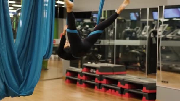 Atraktivní žena dělá leteckou jógu strečink cvičení v houpací sítě ve fitness studiu. Zdravý životní styl pro ženy. Tělocvična cvičení