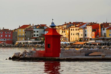 Slovenya 'nın Piran kentinde küçük deniz feneri kırmızı kulesi ve renkli evler.