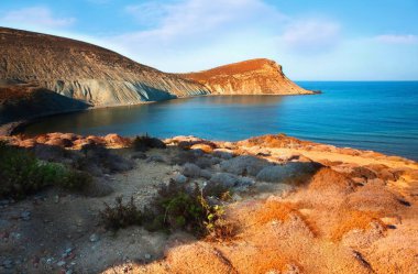 Lemnos Adası 'ndaki Cape Faraklo (Limnos da denir), Yunanistan. Mavi koy, kayalar, tepeler ve kekik çalıları Yazın sonlarında güneşli bir günde.