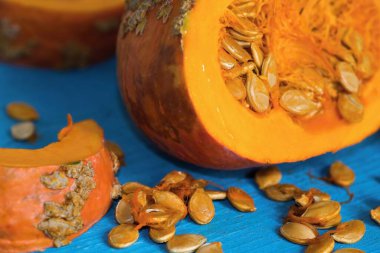 Balkabağı hokkaido, masada tohum ile kesilmiş, mavi ahşap arka planda yakın plan