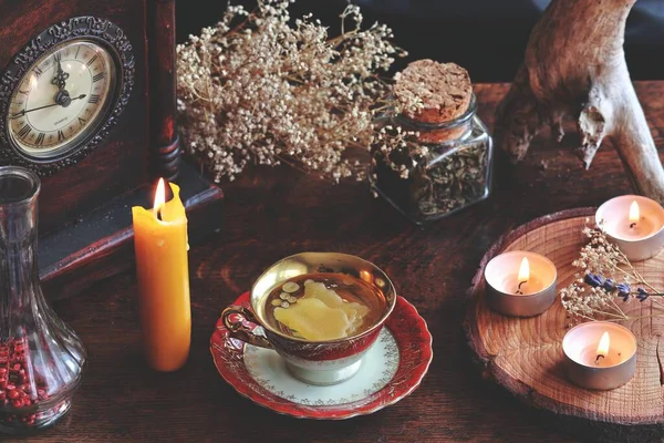 蜡烛蜡倒入一个红色和金色的老式茶杯 作为一种占卜形式 旁边站着一支黄色的燃烧的蜡烛 阅读烛光蜡 狂欢节 自然物品中的陶瓷镜片 — 图库照片