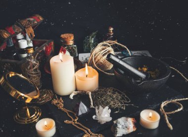 Witch's working space. A very messy witch's altar filled with random tidbits like mortar and pestle, burning white candles, gold mirror, dried herbs flowers, crystals and a chest box with oils and tinctures clipart