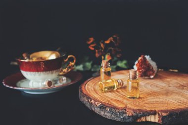 Wiccan cadı sunağı çalışmaya hazır, içinde küçük iksir şişeleri gibi görünen küçük yağ şişeleri, ya da özü, gerekli yağlar, ya da diğer sarı yağlar. Siyah arkaplanda çay fincanı ve kristaller
