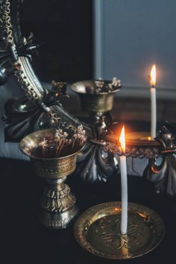 Ayna büyüsü büyücülüğü. Alevi okumak için yanan beyaz bir mumla scrying. Sıska bir mum çubuğunun arka planda altın rengi antika eşyalar, mum tutacağı, tütsü yakacağı olan karanlık, modası geçmiş bir aynadaki yansıması.