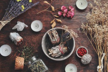Wiccan cadı sunağında yakmak için kil çömlekte adaçayı lekesi. Enerji temizleme büyüsü. Duman temizleme hava sahası odası. Kurumuş çiçekler, doğa malzemeleri, mumlar, arka planda kristaller.