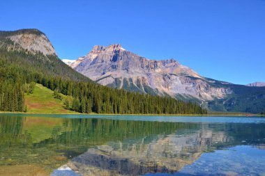 Güzel mavi zümrüt gölü, sudaki dağların yansıması. Güneşli bir gün, mavi gökyüzü. Kanada.