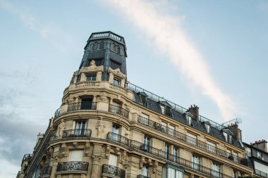Paris 'in kavşağında kavisli bulutlu bir apartman.