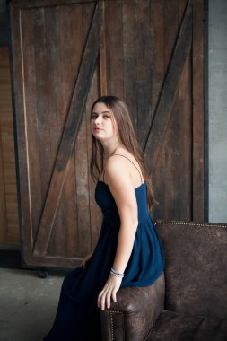 Gece elbisesi içinde genç ve güzel bir kadın çatı katında poz veriyor ve dans ediyor.