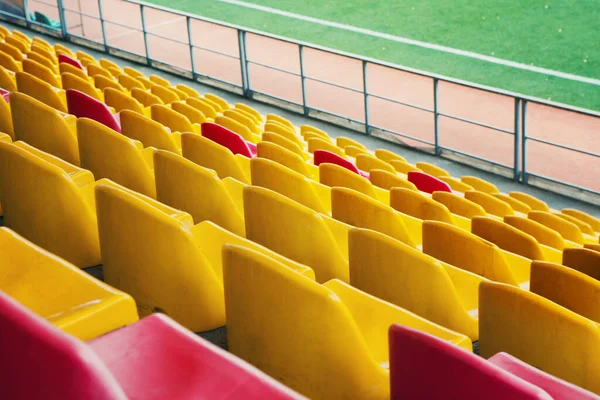 Empty stadium. Rows of yellow and red seats in stadium. Concept of empty stadium without spectators, quarantine time