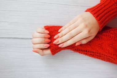 Tırnaklarında mercan manikürlü güzel kadın elleri. El kremi ve tedavi için. El bakımı