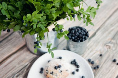 Böğürtlenler kupa ve buket orman yaprakları ve kovada böğürtlenler, ev yapımı kek ve renkli ahşap arka plan.