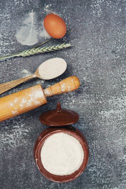 Evde ekmek pişirmek için gereken malzemeler, un, yumurta, koyu ahşap arka planda buğday filizi. Boşluğu kopyala