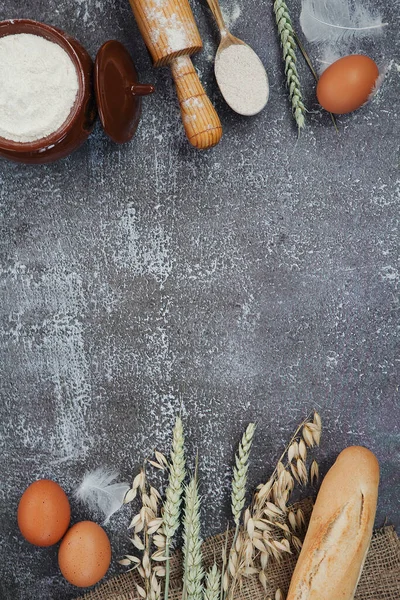 Koyu ahşap arka planda buğday, baget ve fırın malzemeleri. Boşluğu kopyala
