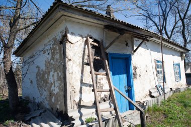 Bahar ağaçlarının arasındaki tepede eski püskü bir ev.